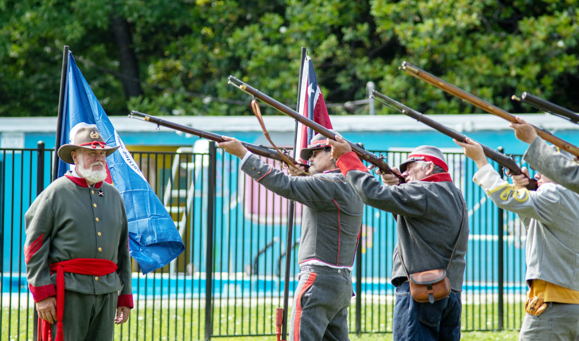 LEFT- Commanded by Barry Kniffen, left, the local chapter of Sons of Confederate Veterans (SCV) performed military honors via firing party utilizing period muskets on Monday at the annual Memorial Day Observance at American Legion Park. Pictured firing, left to right is Wayne Carlile, Danny Masters, Bayden Fleming. Sandy Kothmann, photo.
