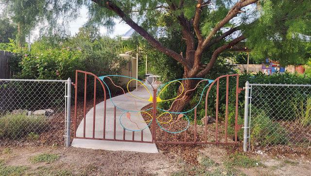 THE DECORATIVE metal gate on the northeast side of the Marjorie Russell Education Garden is now complimented by the addition of a cement walkway to the pavilion. Courtesy photo.