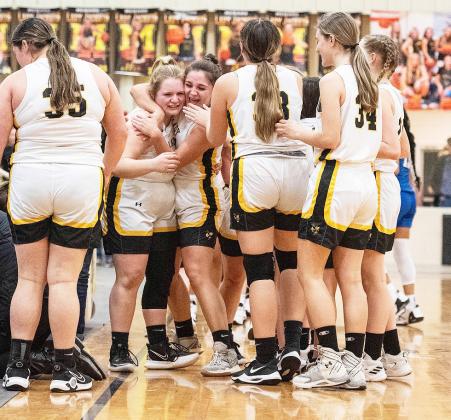 Lady Jackets Mackenzie Wagner and Makinley Kothmann, center, hug in celebration of their 'redemption' win over Eden last week. The outcome resulted in Menard and Eden being named district co-champions. Sandy Kothmann, photo.