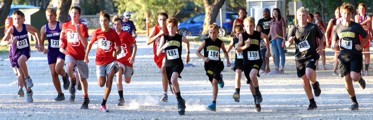 ON YOUR MARKS. GET SET. GO! Junior Jacket cross country runners, to the right in dark jerseys, launch off the starting line of the Irion County meet. Menard runners pictured are, L-R- Bryce Davis (#191), Jaeger Leonard, Brayden Ramon, Tucker Pullen, Tate Wagner, Cado Bannowsky. Photo by Nora Davis.