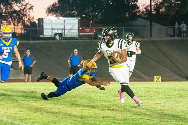 THREE FOR THE MONEY- Senior Jayden Payton (#3) eludes a Medina Bobcat during the Jackets' 62-40 district win last week. Medina,now 6-2 on the season and 1-1 in district, started out the game scoring on the first play of the game. The competition was uncomfortably close throughout the first half, before Menard was able to pull ahead and get the win to become 2-0 in district. Nora Davis, photo.