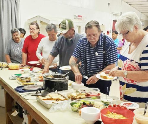 Carolyn and Ed Keith make their food selections at Menard’s American Legion Post 378 potluck supper, which is held on the first Tuesday of the month.