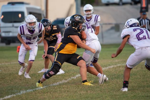 TOUCHDOWN, SQUIERS! Senior Yellowjacket Korbin Squiers, center, battled through with his Menard JV counterparts against a tough Irion County JV team last week to score the first touchdown of his high school career. Sophomore Benjamin Burch (#54) looks on. Menard came out on top 54-8.  Nora Davis, photo.