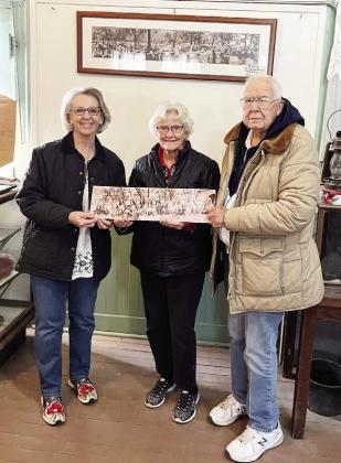 MUSEUM ADDITION- Judy Stewart (pictured left) and husband Craig (not pictured) recently donated a photo to the Menardville Museum collection. The print features Texas Rangers gathered during their 1927 summer meeting in Menard. Judy's grandfather is believed to be in the photo. Katherine and John Kniffen, pictured, accepted the photo of the museum which is now reopened after a brief reorganization. Courtesy photo.