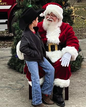 SANTA CLAUS CAME TO TOWN- Second grader Camden Ramon had a nice visit with Santa on December 10 at the low water park amongst hundreds of the city’s festive Christmas lights. Courtesy photo.