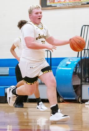 Senior Yellowjacket Tate Wagner makes his way down the court in the Jackets’ district win over Olfen. Nora Davis, photo.