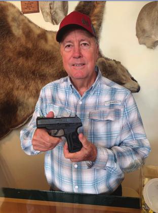Gary Roberson holds the Ruger Max-9 being raffled off to raise money for equipment the Menard Sheriff’s Office needs to help combat crime and drugs in town.