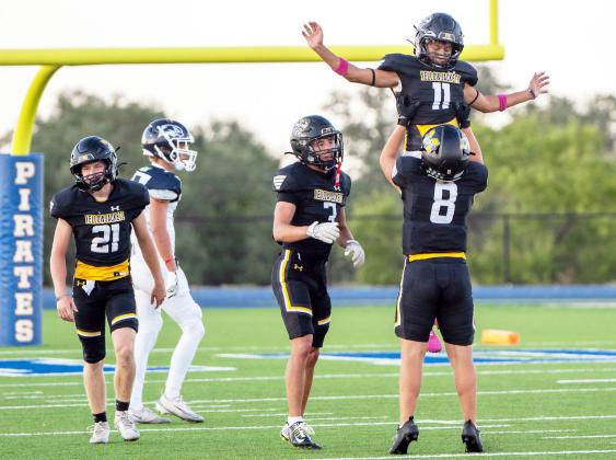 ABOVE- Mack Davis lifts Maddox Saiz in c e l e b r a t i o n of Kade Bannowsky (far left) blocking a Falcon punt, resulting in a safety. Cohen Ethridge joins in.