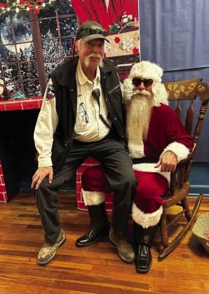 Santa made a very special visit to Menard Elementary School last week, and Resource Officer Constable Callan did not miss a chance to tell the big guy what he wants for Christmas! Courtesy Photo.