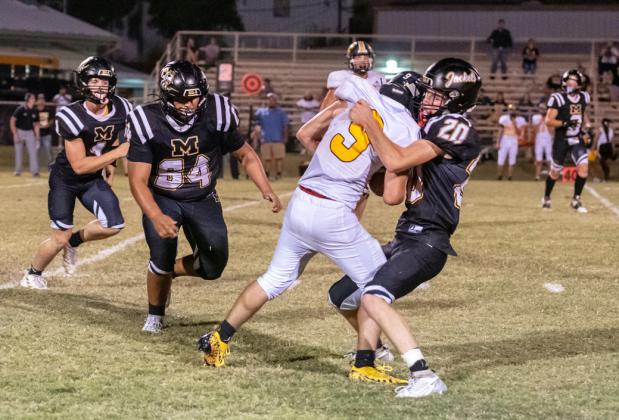 LET’S DANCE- Senior Bryce Davis (#20) lovingly brings down a Tiger ball carrier in Fridays Yellowjacket win over Blanket. Zeke Hernandez (#64) and Eli Weatherly (#4) are also pictured.