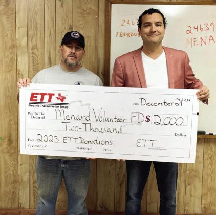 Assistant Fire Chief Jeff Whitson, left, accepts a VFD donation from Eddie Pallarez on behalf of Electric Transmission Texas (ETT).