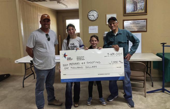 Menard County Farm Bureau board member Tyson Roll presents a check for $1,000 to the Menard 4-H Shooting Sports program. Shooters Mia Estrada and Kylie Smith graciously accept the donation check with Coach David Hand. Courtesy Photo.