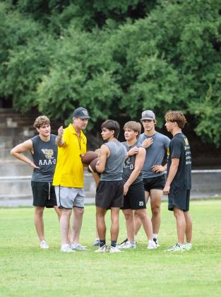 HEAD COACH Clay Holland instructs a group of Yellowjacket football players in preparation for the 2026 season. Pictured left to right: Caden Bounds, Holland, Julius Zamora, Mack Davis, Wesley Compton, Cohen Ethridge. Nora Davis photo.