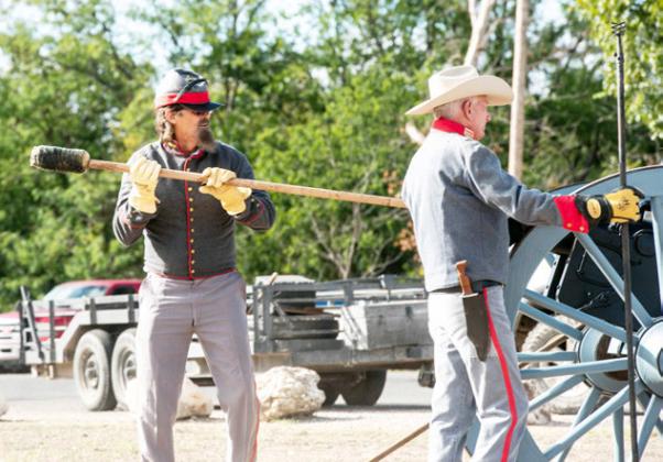 RIGHT- Historical reenactors Wayne Carlile and Buck Bostwick prep the 'Alamo' canon to fire last Saturday. Sandy Kothmann, photo.