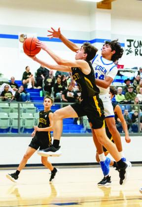 YELLOWJACKET Eli Weatherly, center, fights a Bulldog for the bucket during Menard's 50-13 routing of Eden last week. Jaegar Leonard in background. Nora Davis, photo.