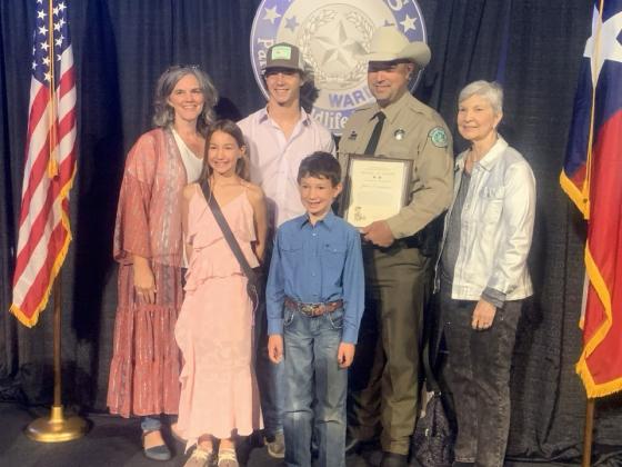 MEDAL OF VALOR recipient, Game Warden John Compton, accepted his prestigious award in a ceremony in Austin on October 23, 2025. There to celebrate the recognition are, pictured front row left to right: two of John's children, Natalie and Deacon Compton. Back row: John's sister Amanda Gross, son Wesley, John, and his mother Linda Compton. Courtesy photo.