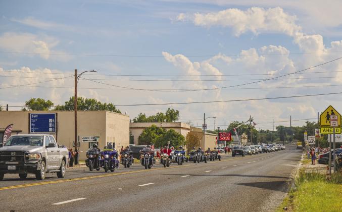 The community stood in somber respect as several agencies escort 19-year-old Lance Corporal Kendal Lawler home for burial in Menard last week. Photo by Cheyanne Nance.