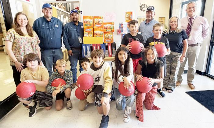 PEC DONATES SUPPLIES- Elementary teacher Myghan Meadow, far left, and principal Cody Holubec, far right, stand with grateful students and Junction PEC District Director Craig Molina, Alex Gonzales and Travis Brown. TMN photo.