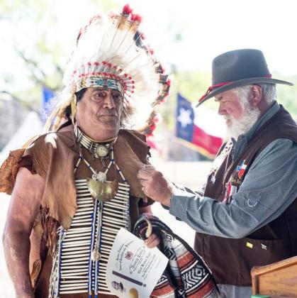 RIGHT- “Chief Broken Eagle,” Ray Hernandez, accepts recognition for his efforts in representing multiple Native American tribes of the area at numerous historical events throughout the years. Barry Kniffen bestowed the honor Saturday during the Sons of Confederate Veterans program at the Presidio de San Saba. The event was complete with cannon fire and full period dress. Sandy Kothmann, photo.