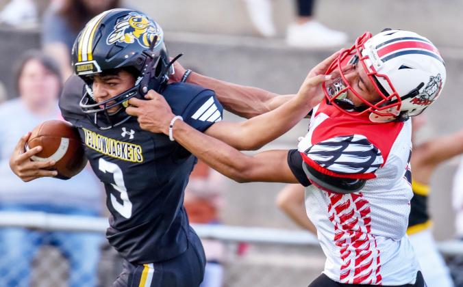BACK AT YA- Sophomore Yellowjacket Jayden Payton returns the face feels of a Mc-Dade Bulldog during Menard's 64-14 routing Friday night. The game was called close to halftime thanks to the 45 mercy rule. Madolyn Nasworthy, photo.