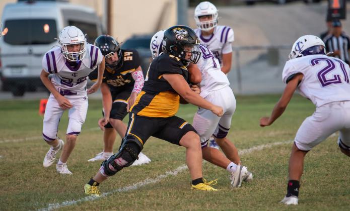 TOUCHDOWN, SQUIERS! Senior Yellowjacket Korbin Squiers, center, battled through with his Menard JV counterparts against a tough Irion County JV team last week to score the first touchdown of his high school career. Sophomore Benjamin Burch (#54) looks on. Menard came out on top 54-8. See additional photos on page 8. Nora Davis, photo.