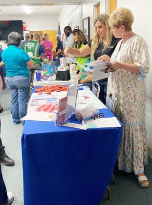 Frontera's Rosanna Roberson and Menard Chamber's Cherry Swindall look over materials available at last week's first-responder- centered events. Courtesy photo.