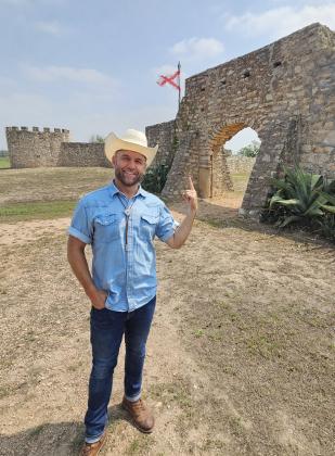 The Daytripper Chet Garner stands at the entrance of the Presidio de San Saba during his show’s filming of Menard. Photo by The Daytripper.