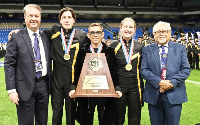 U.I.L. CLASS A STATE MARCHING BAND CHAMPIONS! AGAIN! Pictured with contest officials at the Alamodome Tuesday night, Drum Majors Aydan Wilson (second from left), Kevin Johnson and Cozette Halley accept their gold medals on behalf of the Yellowjacket Band. Details and additional photos will be included in next week's newspaper. Photo by Jolesch Enterprises.