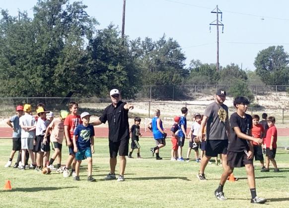 LIKE A CHAMP- Accomplished six-man football coach Mike Reed (left) of Gordon, came to Menard for some football instruction at all age levels last week. TMN photo.