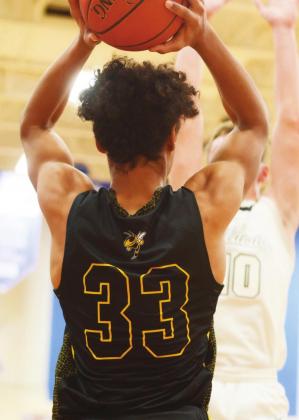 LEFT- Junior Isaiah Stanislawski searches for a clear pass in Menard’s playoff loss against Water Valley on Monday, Feb. 21. Photo by Sandy Kothmann.