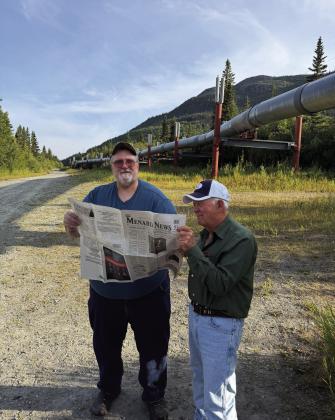 GOOD NEWS TRAVELS- Kelly Miller and Rhome Hill share The Menard News standing under the Trans Alaska Pipeline viewpoint in Copper Center, Alaska. Ginger and Rhome Hill recently traveled to Alaska to Wasilla, Alaska visit dear friends, former Menardians, Kelly and Diane Miller. Kelly is the son of the late Patty (Song of Silver author) and Bobby Miller. Courtesy Photo.