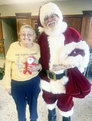 MUCH TO THE DELIGHT of Menard Manor resident Pennye White, Santa made time to stop by the Manor during his Saturday visit. Pennye is a big fan of the Big Guy! Courtesy photo.