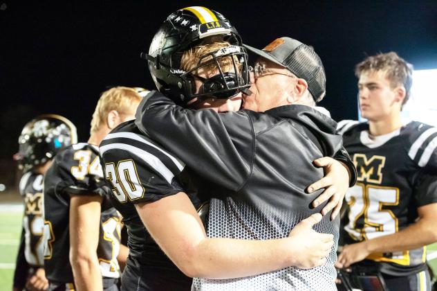 Beloved Menard coach Jeffrey Campbell, right, consoles junior Tate Wagner (#30) after the Jackets' loss to #1 Gordon last week in the area playoff round. Menard was yet another victim in the Gordon Longhorns undefeated season. The defending state champs, Gordon, has not played a third quarter in more than 2 seasons, as they tend to 45 their opponents by the half. This group 45'd fellow 6-man powerhouse Westbrook last year in the state championship. Nora Davis, photo.