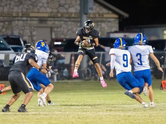 FLOAT LIKE A BUTTERFLY, STING LIKE A YELLOWJACKET- Menard’s Maddox Saiz, center, jumps to retrieve a punt that bounced during the Jackets’ 64-0 win over Rochelle last week. Nora Davis, photo.