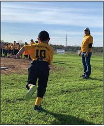 HERE WE GO! Number 10 joins his team on the Menard Youth Baseball field during opening ceremonies Saturday. Volunteer coach/player wrangler Deidra Waggoner stands by. MYB has 11 total baseball and softball teams this year. Ages range from 3 years up to 14. Games are played both in Menard and surrounding towns. TMN photo.