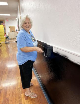 Rosa Gonzales finishes off a section of the elementary hallway’s new look. A whole crew of staff and their families dedicated a week of their time to provide a bright and fresh change for a fresh new school year. The community effort is sure to be enjoyed by the incoming students! Courtesy photo.