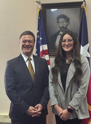 MR. MENARD LOOKS ON: The Honorable Rob Hoffman, 452nd District Judge, left, with newly sworn-in juvenile probation officer Calley McSherry. Mr. Menard, background, looks on approvingly from his frame in the courthouse.