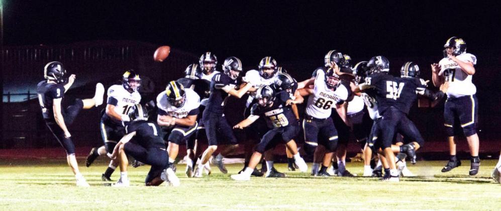 NOT TODAY, EAGLES! Senior Zadrian Zapata (#21, head down) busts through Junction’s line to block their point after. The denial of this extra point ended up being the game-winner in Menard’s 7-6 win Nora Davis, photo.