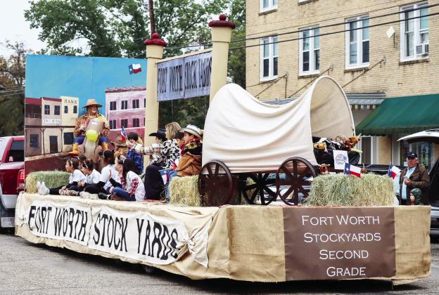 SECOND GRADERS and their teachers, Amy Allison and Gwenda Neel, ride atop their grand champion float in Saturday's annual PTO Veterans Day Parade. This year's parade boasted 33 total entries. The cool wet weather did not deter the crowds; the streets were packed with parade watchers. Laressa Brown, photo.