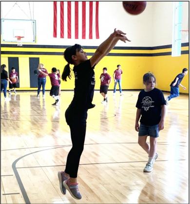RIGHT-Sara Ogden warms up before the Menard girls grades 3/4 team takes on Paint Rock. Teammate Kayla Trimble looks on.
