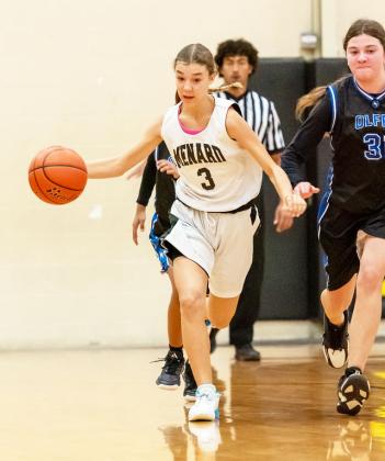 RIGHT- Seventh grader Shelby Compton works the ball down the court in a junior high win over Olfen. Nora Davis, photo.