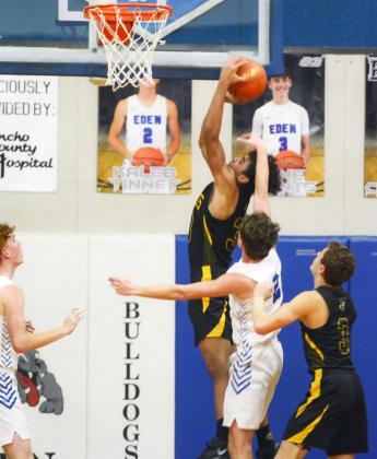 Menard junior Isaiah Stanislawski receives a pat on the head from an Eden defender during the Yellowjacket win over the Bulldogs last Tuesday, February 1. Teammate Joel Guerrero awaits the rebound. The Jackets pounded Paint Rock 55-30 this week, and will face Veribest on Friday, February 11, in Veribest. Sandy Kothmann, photo.