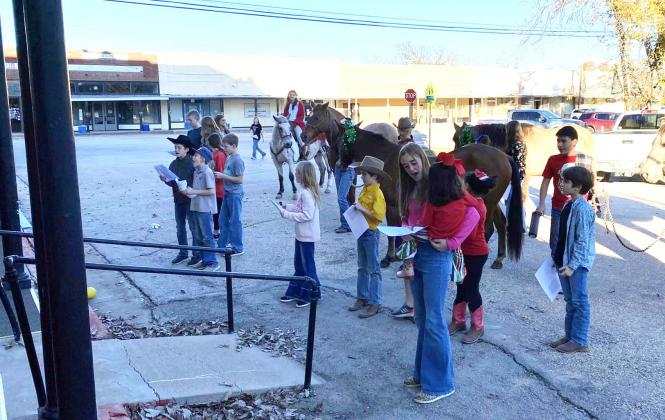 THE MENARD 4-H HORSE CLUB rounded up their steeds and joined other 4-H members in serenading the residents and staff at Menard Manor before Christmas last week. Lisa Brown, photo.