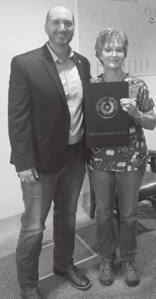 LEFT- Menard County Judge Brandon Corbin presents Dr. Janis Cordes a resolution from the State of Texas, honoring her late husband, Dr. and Judge Richard Cordes. Courtesy photo.