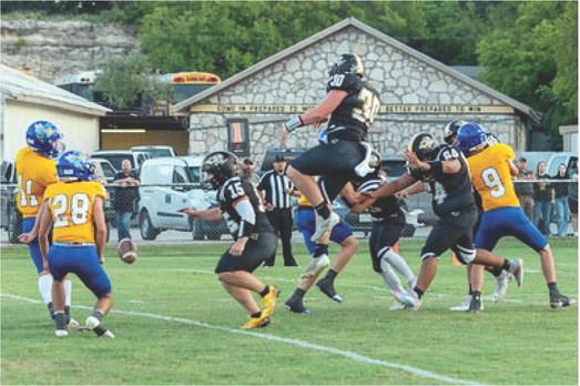 FIGHTIN' BACK- Menard's Tate Wagner defies gravity to block a Rochelle PAT in last Friday's 34-83 loss to Rochelle. Nora Davis, photo.
