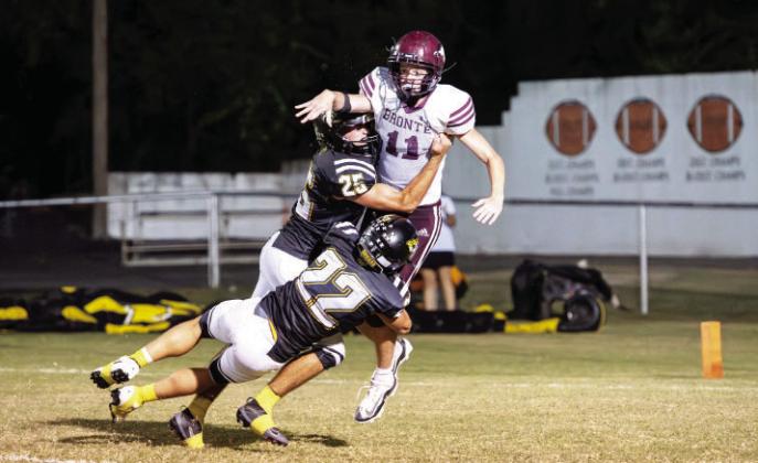 HAPPY HOMECOMING was the message sent and received by a bewildered Longhorn via Cado Bannowsky (25) and Wesley Compton (22) during the Jackets' 51-0 smoke down of Bronte last Friday. The game was over at the half which left plenty of time for both schools' bands to march and ladies to be crowned. See additional football photos thanks to our Jacket Backers on page 10. Nora Davis, photo.