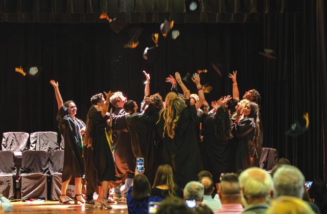 MENARD HIGH SCHOOL’S freshly graduated class takes the traditional cap toss upon the school auditorium stage. Graduations are usually held outdoors at Findlay Field, but the weather had other plans this year. You can read about each graduate in the special graduation feature that will be in next week’s newspaper. The publication was anticipated to be available today, but has since been delayed.