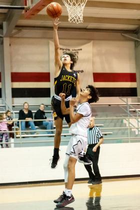 RIGHT- Menard's Marlee Salas goes above and beyond during the Jackets win over Panther Creek last week. Nora Davis, photo.
