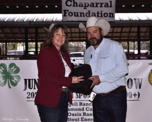 Payton Chambless accepts a thank you gift on behalf of O Diamond Ranches from Texas Agrilife Exertion Agent Lisa Brown for being one of the top 2023 buyers.