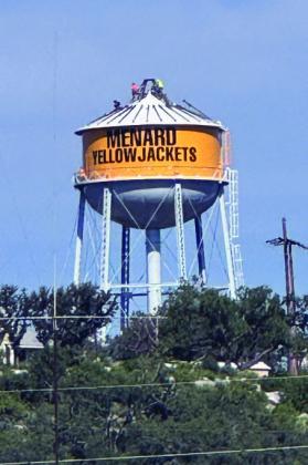 RIGHT- Look closely to see contracted crews continuing work atop the city's water tower. Upgrades are coming along, as evident by the new bold gold color and the addition of the town and mascot. Interestingly, the specifi c yellow/gold color used is Green Bay Gold, and the city was required to get permission from the Green Bay Packers in order to use the cheery hue. TMN photo.